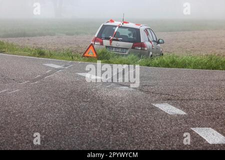 Ein Auto auf einer Wiese, ein Unfall mit Warndreieck, Bremsspuren zeigen, dass das Fahrzeug die Landstraße Rheinmünster, Baden-Württemberg verlassen hat Stockfoto