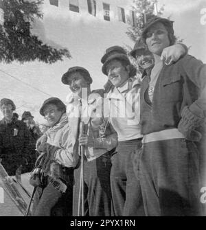 Sportlerinnen posieren für die Kameras, ganz rechts auf dem Bild ist ein Teilnehmer aus Schweden. Unbefriedigtes Bild, wahrscheinlich im Winter 1933/34. Stockfoto