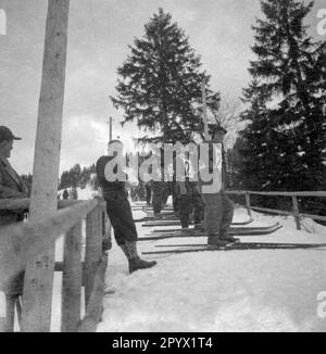 Skispringer eines internationalen Wettkampfs in Garmisch warten auf ihren Sprung vom Hügel. Unbezahltes Foto, wahrscheinlich im Winter 1933/1934. Stockfoto