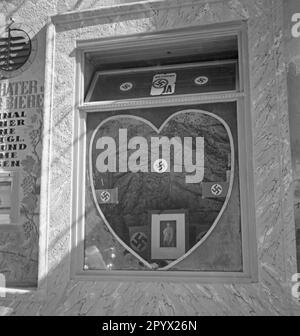 Ein Schaufenster in Wien wurde in Herzform gemacht. Hinter der Scheibe ist ein Bild von Adolf Hitler und Hakenkreuzen. Das Referendum fand am 10. April 1938 statt. Stockfoto