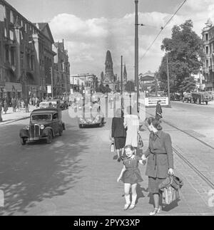 Undatiertes Foto einer Straßenszene am Kurfürstendamm in Westberlin, britische Besatzungszone, im Sommer 1950. Im Vordergrund, Fußgänger, die die Straße überqueren. Rechts, teilweise zerstörte Häuser. Im Hintergrund der Eingang zur U-Bahn-Station Kurfürstendamm. Dahinter befindet sich der zerstörte Turm der Kaiser-Wilhelm-Gedächtniskirche (Hollow Tooth). Stockfoto