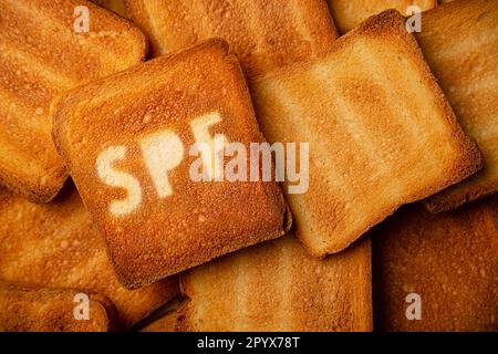 Konzept der SPF-Creme auf dem Hintergrund von Toastbrot. Speicherplatz kopieren. Stockfoto