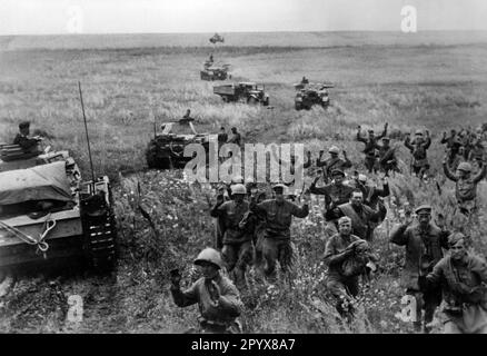 Russische Soldaten ergeben sich und gehen an einer deutschen Panzereinheit vorbei in Gefangenschaft. Vor einem Panzer III, im Hintergrund einem Panzer IV Das Foto wurde während der deutschen Offensive in der Südukraine in Richtung Stalingrad aufgenommen. [Maschinelle Übersetzung] Stockfoto