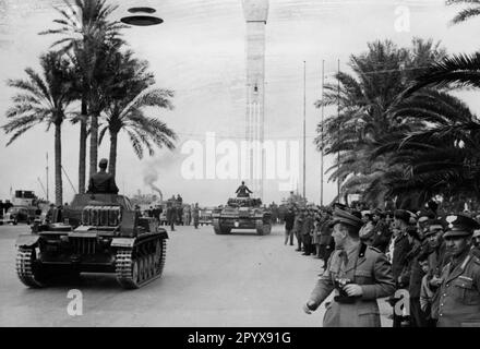 Eine Kolonne von Panzerkampfwagen II und III des deutschen Afrika Korps fährt während einer Parade durch Tripolis. Italienische Soldaten sind im Vordergrund zu sehen. Foto: Borchert [maschinelle Übersetzung] Stockfoto