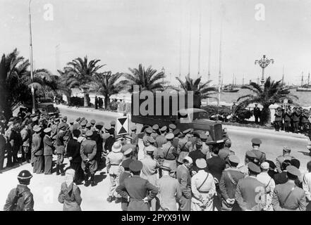 LKW Opel Blitz vom Deutschen Afrika-Korps in Tripolis, umgeben von Soldaten auf einer Fahrt vorbei an Generalleutnant Erwin Rommel (in der Offiziersgruppe). Auf dem Bild ist auch die Standhaftigkeit des kommandierenden Generals eines Korps. Foto: Sturm [maschinelle Übersetzung] Stockfoto