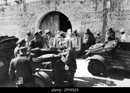 Soldaten des deutschen Afrika-Korps nehmen Essen. Rechts im Bild ein VW Kübelwagen. Foto: Moosmüller [maschinelle Übersetzung] Stockfoto