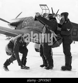 „Der Pilot eines Junkers Ju 87 ''Stuka'' wird vor dem Start 'gekleidet'' und half beim Anbringen des Fallschirms. [Maschinelle Übersetzung]' Stockfoto