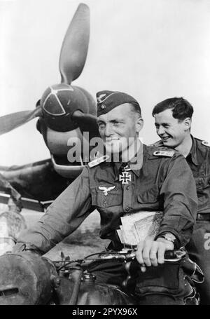 'Pilot Peter Gaßmann mit seinem Schützen vor seinem Junkers Ju 87 ''Stuka''. Das Flugzeug im Hintergrund zeigt das Schleuderbild (schwarz-rot), das typisch für die III-Gruppe des Stuka-Geschwaders 1 ist. Foto: Stempka“ Stockfoto