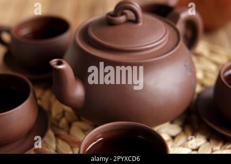 Teezeremonie. Traditionelles Asiatisches Teeutensil, Serviert Authentisches Set. Person, die Tee von der Teekanne aus brauner Keramik bis zur Teekanne einschenkt. Bambusschale. Lifestyle. Wir Stockfoto