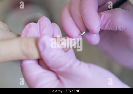 Nägel Maniküre mit Feile oder Bürste. Frau schöne Nagelpflegeprozesse. Stockfoto