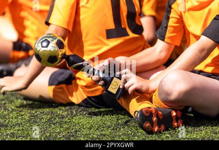 Junger Junge in Sportkleidung, der den Handfußball-Trophäe-Preis erhält. Football Boy mit dem wertvollsten Player Award Stockfoto