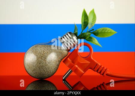 Stöpsel, Pflanze wächst in der Glühbirne und Russische Flagge. Konzept für umweltfreundliche erneuerbare Energien. Stockfoto