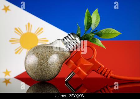 Stöpsel, Pflanze wächst in der Glühbirne und Philippinen-Flagge. Konzept für umweltfreundliche erneuerbare Energien. Stockfoto