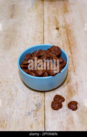Schokoladen-Müsli in einer Schüssel oder einem Teller auf einem Holztisch Stockfoto