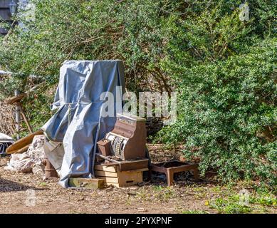 Eine alte Auswahl alter Gegenstände, die sich in einem Hof stapeln Stockfoto
