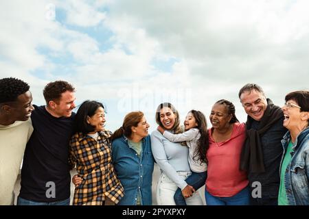 Glückliche, generationenübergreifende Freunde mit unterschiedlicher ethnischer Zugehörigkeit, die Spaß auf dem Dach des Hauses haben - Diversity People Lifestyle Stockfoto