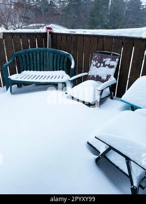 Gartenmöbel auf einer Terrasse, bedeckt mit einer dicken Schicht frischen Schnees. Stockfoto