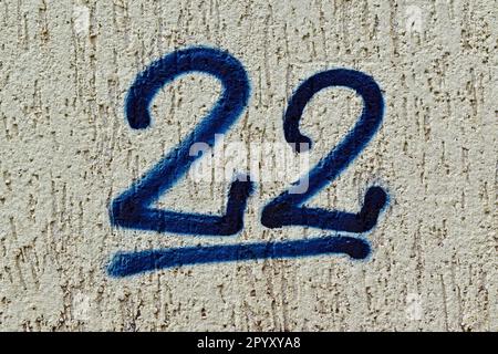 Nummer 22 in blau an einer grauen Wand Stockfoto