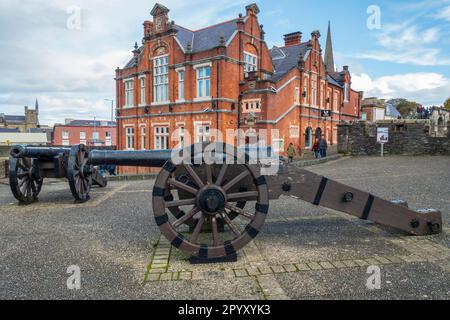 Kanonen der königlichen Bastion an den alten Stadtmauern, mit renoviertem Gebäude der First Derry School im Hintergrund, Derry / Londonderry, Nordirland, Großbritannien Stockfoto