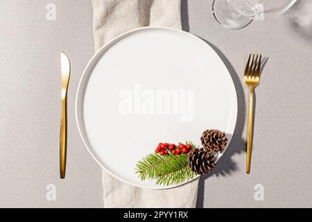 Eleganter Tisch für Winterhochzeiten oder Weihnachtsessen, goldene Utensilien, Blick von oben Stockfoto