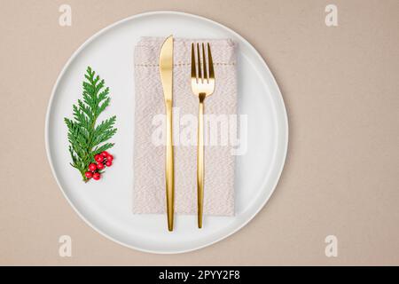 Teller mit goldener Serviette und Besteck, wenig Tischdecken, Draufsicht Stockfoto