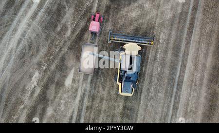 Ein großer Lkw steht auf einem Feld, auf dem zahlreiche landwirtschaftliche Maschinen verteilt sind Stockfoto