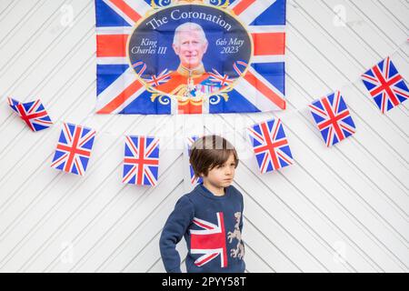 Halesowen, West Midlands, Großbritannien. 5. Mai 2023. Der 6-jährige Zachary Hickin steht vor dem Garagentor seiner Familie, das für den Krönungstag von König Karl III. In Halesowen, West Midlands, dekoriert ist. Kredit: Peter Lopeman/Alamy Live News Stockfoto