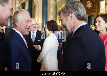 König Karl III. (Links) begrüßt Mary, Kronprinzessin von Dänemark und Kronprinz Frederik von Dänemark, bei einem Empfang im Buckingham Palace in London für ausländische Gäste, die an seiner Krönung teilnehmen. Foto: Freitag, 5. Mai 2023. Stockfoto