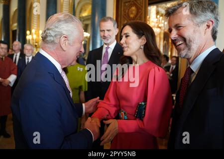 König Karl III. (Links) begrüßt Mary, Kronprinzessin von Dänemark und Kronprinz Frederik von Dänemark, bei einem Empfang im Buckingham Palace in London für ausländische Gäste, die an seiner Krönung teilnehmen. Foto: Freitag, 5. Mai 2023. Stockfoto