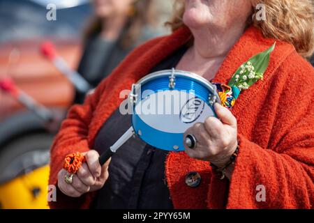 Carhaix, Frankreich - Mai 1 2023: Demonstration gegen die Rentenreform mit einer älteren Dame, die ein Tamburin missbilligt. Stockfoto