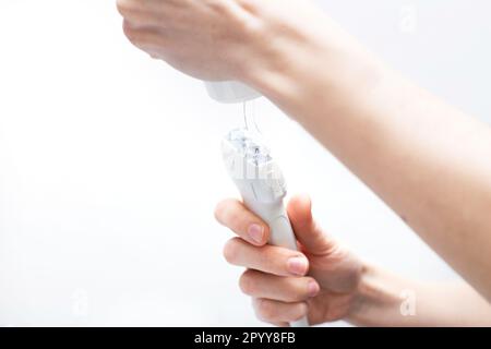 Die Hand des Arztes trägt ein medizinisches Gel auf den Ultraschallsensor des Ultraschallgeräts in der Klinik auf. Stockfoto