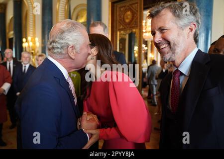 König Karl III. (Links) begrüßt Mary, Kronprinzessin von Dänemark und Kronprinz Frederik von Dänemark, bei einem Empfang im Buckingham Palace in London für ausländische Gäste, die an seiner Krönung teilnehmen. Foto: Freitag, 5. Mai 2023. Stockfoto