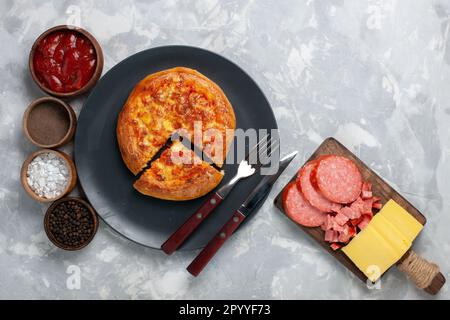 Top View gebackene Pizza mit Gewürzen auf dem leichten Schreibtisch Pizza Teig Backen Essen Stockfoto