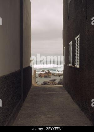 Pfad zu den Felsen und zum Meer zwischen zwei Häusern auf den Kanarischen Inseln Stockfoto