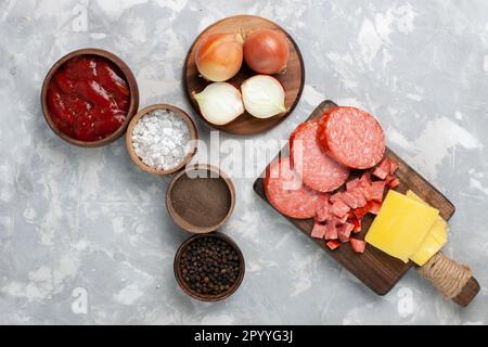 Blick von oben auf verschiedene Gewürze mit Würstchen auf weißem Hintergrund Essen Gemüse Stockfoto