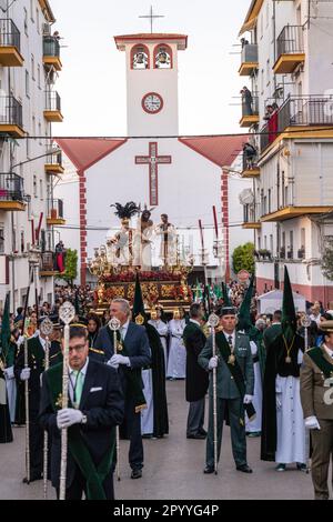 Die Nazarenos tragen eine riesige Plattform mit einer Statue von Jesus Christus und den Römern in einer Prozession während der Heiligen Woche oder Semana Santa, 5. April 2023 in Ronda, Spanien. Ronda, die sich im 6. Jahrhundert v. Chr. niedergelassen hat, hält seit über 500 Jahren Heilige Woche-Prozessionen ab. Stockfoto