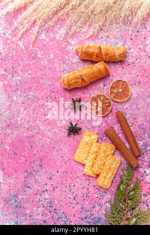 Süße Bagels mit Crackern auf pinkfarbenem Hintergrund in süßer Kuchenfarbe Stockfoto