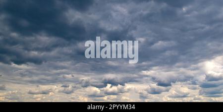 Schwarze Sturmwolken und heller Horizont am Himmel. Stockfoto