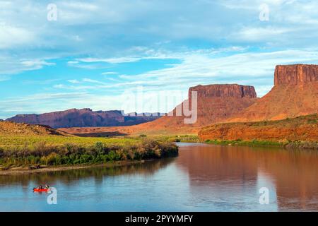 Rafting auf dem Colorado River mit Tafelbergen bei Sonnenuntergang in der Nähe von Moab, Arches-Nationalpark, Utah, USA. Stockfoto