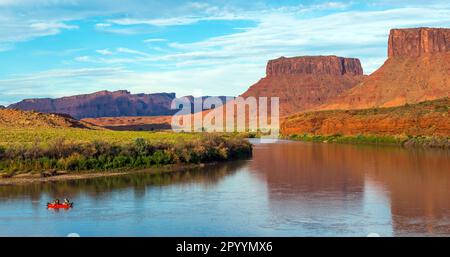 Panoramafahrt auf dem Colorado River mit Tafelbergen bei Sonnenuntergang, Moab, Arches-Nationalpark, Utah, USA. Stockfoto