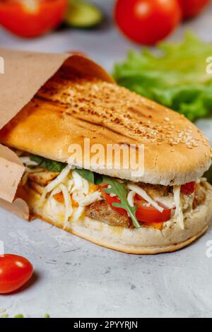 panini-Sandwich mit knusprigem Huhn und Rucola-Salat Stockfoto