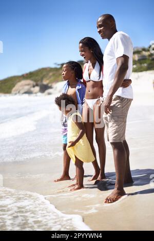Es ist überhaupt nicht kalt. Eine afroamerikanische Familie, die einen gemeinsamen Tag am Strand genießt. Stockfoto