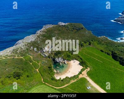 Luftaufnahme auf die kleine Playa de Gulpiyuri, überflutetes Sinkloch mit Binnenstrand in der Nähe von Llanes, in Asturien Nordspanien, rund 100 m vom Kantabrischen Meer, Stockfoto
