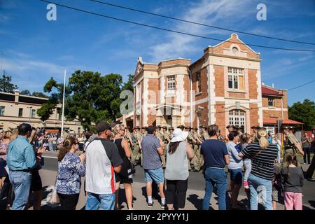 Die Massen kommen heraus, um die Soldaten der Armee zu beobachten und anzufeuern, die auf der ANZAC Day Parade die Hauptstraße von Singleton entlang marschieren Stockfoto