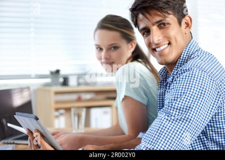 Wir haben es geschafft. Zwei Kollegen, die im Büro arbeiten. Stockfoto