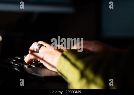 Sonnenlicht auf verheirateten männerhänden, die auf einem Desktop-Computer auf der Tastatur tippen Stockfoto