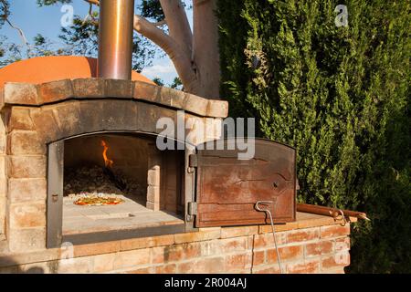 Pizza zum Mittagessen im hausgemachten Pizzaofen auf dem Bauernhof Stockfoto