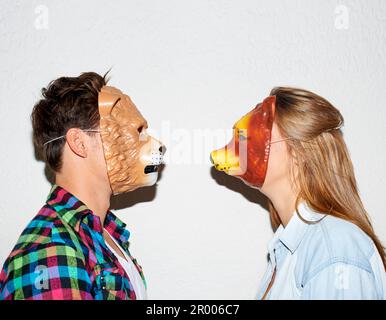 Weil normal langweilig ist. Freunde haben Spaß zusammen mit Masken. Stockfoto