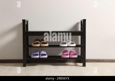 Aufbewahrungsbank mit Paar Gummipantoffeln im Innenbereich Stockfoto