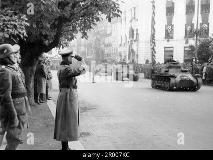 General Bernhard von Brauchitsch begrüßt die vorbeiziehenden Truppen, die nach der Annexion des Sudetenlands durch eine Stadt in der Tschechoslowakei ziehen. Nach der Annexion Österreichs verlangte Hitler, dass er in die Region Sudeten der Tschechoslowakei aufgenommen wird. Auf der Münchner Konferenz im September 1938 stimmten die westlichen Mächte dem zu, und die nazis besetzten das Gebiet. Kurz nachdem Hitler sein Versprechen gebrochen hatte und in den Rest der Tschechoslowakei einmarschierte, widmete er sich Polen. Bundesarchiv, Bild 146-2005-0181/CC-BY-SA 3,0 Stockfoto